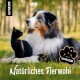 Ein freundlicher Australian Shepherd und eine schwarze Katze sitzen zusammen im Gras, mit "Natürliches Tierwohl" und dem "ALPHAZOO"-Logo in der Ecke.