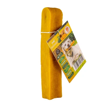 Kurkuma Käsekauknochen M Ein gelbes Hundekauspielzeug mit einer strukturierten Oberfläche, das an einem bunten Etikett befestigt ist, auf dem ein Hund mit einem Kauknochen abgebildet ist, sowie Nährwertinformationen und einem Barcode.