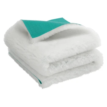 Gefaltete weiße flauschige Haustierdecke mit türkis strukturierter Unterseite, vor weißem Hintergrund gezeigt.