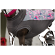 Eine Nahaufnahme eines dunkelbraunen Hundes, der eine stilvolle graue und blumengemusterte Hundeweste trägt, mit einem sichtbaren rosa Halsband.
