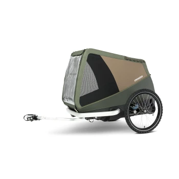 Ein Haustieranhänger in Grün und Braun, mit einem Netz vorne zur Belüftung, der an einem Fahrrad mit einer weißen Anhängerkupplung befestigt ist.