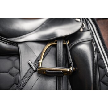 Nahaufnahme eines schwarzen Reitsattels mit einem goldenen Steigbügel mit der Aufschrift "EQUINATE", das detaillierte Lederhandwerkskunst und Nähte zeigt.