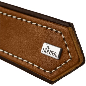 Nahaufnahme eines braunen Leder-Haustierhalsbands mit weißer Naht und einem silbernen "HUNTER"-Logo-Anhänger.