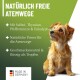 Ein kleiner, flauschiger Hund schaut nach oben, umgeben von grünem Hintergrund. Der Text hebt natürliche Zutaten für die Atemwegsgesundheit hervor, hergestellt in Deutschland.
