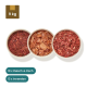Haustierfutterprodukte: drei vakuumverpackte Pakete mit der Aufschrift "Fleisch" und "Thunfischfilet," plus Schalen mit Hackfleisch und Fisch.