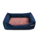 Marineblaue Haustierliege mit plüschigen Seiten und einem weichen rosa Kissen, mit einem kleinen Holzschild an der Seite.