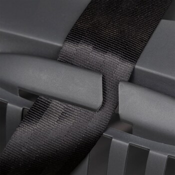 Nahaufnahme einer grauen Haustiertrage mit einem schwarzen Riemen, der um den Griff gesichert ist, was Haltbarkeit und Design betont.