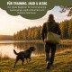 Olivgrüne Reisetasche für Haustiere mit einem orangefarbenen Hundespielzeug und einer schwarz-silbernen Wasserflasche im Freien.