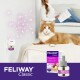 Eine entspannte orangefarbene Katze sitzt auf einer weichen Oberfläche, neben Feliway Classic Produkten, einschließlich eines Diffusors und einer Flasche, die eine glückliche Katzenumgebung fördern.