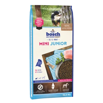 Bosch Mini Junior Hundefuttertüte, 15 kg, mit einem Welpen auf der Vorderseite, mit Text, der 26% Protein, 17% Fett und 'Kolosrum' hervorhebt.