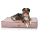 Ein glücklicher Australian Shepherd Hund liegt auf einem plüschigen, rosa Cord-Haustierbett mit einem Lederetikett, auf dem "KNUFFERWUFF" steht.