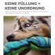 Nahaufnahme des Gesichts eines Hundes mit einem bunten flachen Spielzeug. Text: "KEINE FÜLLUNG = KEINE UNORDNUNG," der die Vorteile des Spielzeugs hervorhebt.