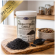 Hände halten eine kleine Dose mit schwarzem Granulat; im Hintergrund unscharf Hundekauartikel; goldenes Siegel mit der Aufschrift „Seit über 15 Jahren“ „Best Quality“.