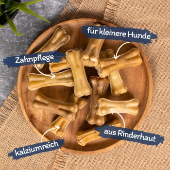 Hundekauartikel in einer Holzschüssel, gekennzeichnet für die Zahnpflege, geeignet für kleine Hunde, kalziumreich, aus Rinderhaut hergestellt.