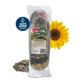Ein Netzbeutel gefüllt mit verschiedenen Samen, darunter Sonnenblumenkerne und Hafer, gesichert mit einem roten Plastikclip an der Oberseite.