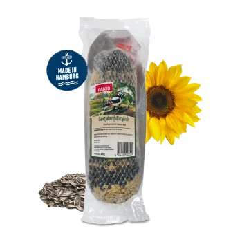 Ein Netzbeutel gefüllt mit verschiedenen Samen, darunter Sonnenblumenkerne und Hafer, gesichert mit einem roten Plastikclip an der Oberseite.