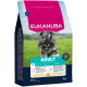 Eukanuba Adult Hundefutterbeutel für kleine Rassen unter 10 kg, reich an frischem Huhn, mit einem Schnauzer auf grünem Gras im Hintergrund.