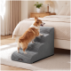 Corgi klettert die grauen, strukturierten Haustiertreppen neben dem Bett hinauf; Etikett 'feandrea' sichtbar.
