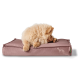 Ein flauschiger Chow-Chow-Welpe ruht auf einem weichen, rosa Haustierbett, mit dem Kopf in die Pfoten gesteckt, und zeigt eine subtile Hundesilhouette an der Seite.