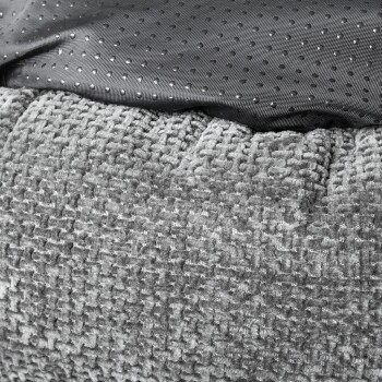 Nahaufnahme eines weichen, grauen Haustierbettes mit einer strukturierten Plüschoberfläche und einer glatten, gepunkteten Stoffoberfläche.