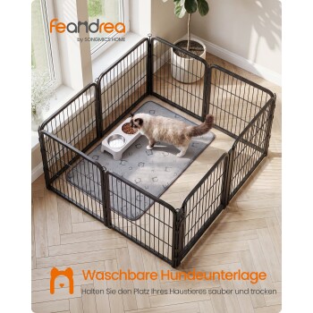 Schwarzes Metall-Auslaufgehege für Haustiere mit langhaariger Katze, grauer Matte und Näpfen; sichtbarer Text: 'feandrea'; 'Waschbare Hundeunterlage'.