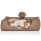 Ein hellbraunes Hundebett mit schwarzem Rand und einem "KNUFFELWUFF"-Logo, auf dem ein verspielter Australian Shepherd bequem liegt.