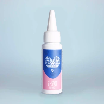 Eine Flasche Z-Spot für Hunde, mit einem blauen und rosa Design mit Pfotenabdrücken und dem Text "Z-SPOT für Hunde" auf dem Etikett.