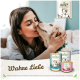 Eine Frau interagiert mit einem Golden Retriever Welpen in der Nähe von drei Dosen von Betty's Hundefutter, die mit "Boswellia" und "Für Hunde" beschriftet sind.