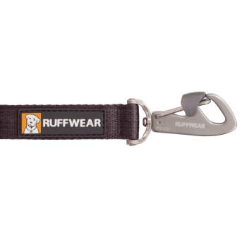 Eine Nahaufnahme einer dunkelvioletten Hundeleine mit einem Metallclip und einem schwarzen und orangefarbenen "RUFFWEAR"-Logo-Patch.