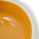 Nahaufnahme einer Futterschüssel für Haustiere mit glänzendem orangefarbenem Innenraum und einem cremefarbenen Rand.
