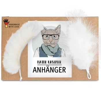 Eine Pappverpackung mit der Aufschrift "KATER KASIMIR ANHÄNGER" mit einer Cartoon-Katzenillustration und zwei weißen Feder-Spielzeugen.