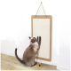Eine Siamkatze, die auf einem wandmontierten Kratzbrett kratzt, mit einer kleinen Spielzeugbanane auf dem Boden in der Nähe.