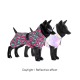 Zwei schwarze Hundemannequins, die bunte Haustierjacken tragen: eine im pink-grünen Leopardenmuster, die andere aus glänzendem reflektierendem Material.