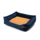 Navyblaue Haustierbett mit einem weichen, tanfarbenen Zentrum und erhöhten Seiten, mit einem kleinen Etikett mit dem Text "petshop.com."
