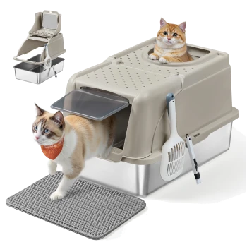 Eine beige Top-Entry Katzenstreu-Box mit einer grauen Matte, eine weiße Katze mit einem orangefarbenen Halstuch verlässt sie, und eine zweite Katze ist drinnen. Eine Schaufel ist befestigt.