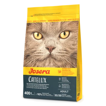 Nahaufnahme des Gesichts einer Katze auf einer Josera Catelux-Tüte, die 'Extrem Anti-Haarballen' und Nährwertdetails wie 92% Fleischanteil hervorhebt.