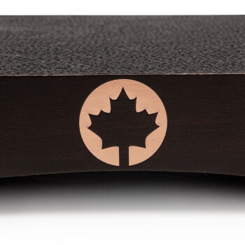 Nahaufnahme eines dunklen Holz-Haustierprodukts mit einem geschnitzten Ahornblatt-Logo auf einer glatten Oberfläche.