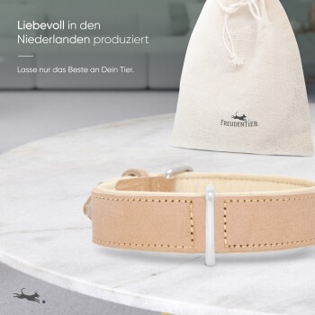 Hellbrauner Leder-Haustierhalsband auf Marmor, neben einer beigen Tasche mit der Aufschrift "FREUDENTIER" und niederländischem Produktionstext.