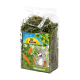 Eine durchsichtige Plastiktüte mit getrocknetem Karottengrün, beschriftet mit 'JR FARM Möhrenkraut', mit einem Cartoonkaninchen, das glücklich von Karotten umgeben ist.