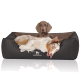 Ein komfortables Hundebett in Dunkelgrau mit einem gesteppten Design, auf dem ein entspannter Hund liegt, das die Marke "KNUFFELWUFFF" zeigt.