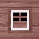 Ein hölzernes Haustierhaus mit einem weiß gerahmten Fenster mit einem Kreuzdesign, vor einer rustikalen braunen Holzwand.
