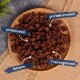 Eine Holzschüssel hält braune würfelförmige Hundeleckerlis, die als proteinreich, leicht verdaulich, fettarm und als Trainingssnack gekennzeichnet sind.