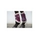 Eine Nahaufnahme von den Beinen eines Pferdes, das lila Schutzstiefel mit weichem, flauschigem Futter trägt, wobei das Markenlogo an den Riemen zu sehen ist.