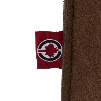 Nahaufnahme eines braunen Haustierzubehörs mit einem roten Etikett, das einen schwarzen Kreis und ein weißes Ahornblattdesign zeigt.