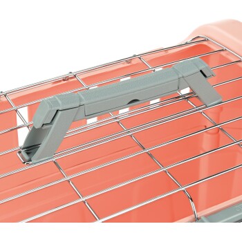 Gros plan sur une poignée grise d'un transporteur pour animaux avec une base corail, présentant un dessus en fil métallique pour la ventilation.