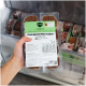 Hand hält gefrorene BARFER'S ‚Komplett‑Mix Junior Rind & Huhn‘ Hundefutter‑Packung (400 g) in einer Gefrierschublade.