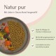 Eine Schüssel mit Hundefutter mit trockenem Futter, frischem Fleisch und Gemüse, die natürliche Zutaten und Eignung für Welpen betont.