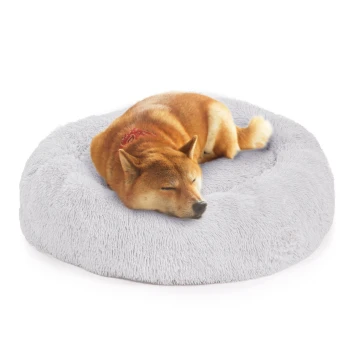 Ein Shiba Inu Hund, der friedlich auf einem weichen, runden grauen Haustierbett schläft, mit einem roten Bandana.