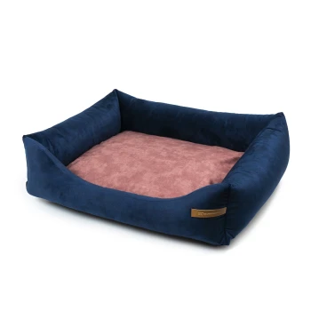 Marineblaues Haustierbett mit weichem rosa Innenraum und erhöhten Seiten, mit einem kleinen braunen Etikett an der Seite.