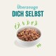 Schüssel mit Haustierfutter, gefüllt mit einer Mischung aus Trockenfutter und Stückchen, mit dem Text "Überzeuge DICH SELBST" darüber.